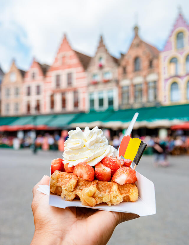 Brugge waffles Belgium, Waffle with cream and strawberry, waffle isolated in hand in Brugge