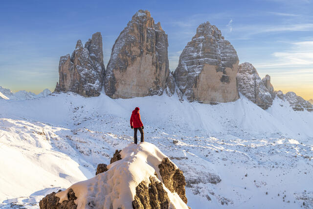 Hiker enjoys the view of the Tre Cime di Lavaredo at sunset, Dolomites, Italy